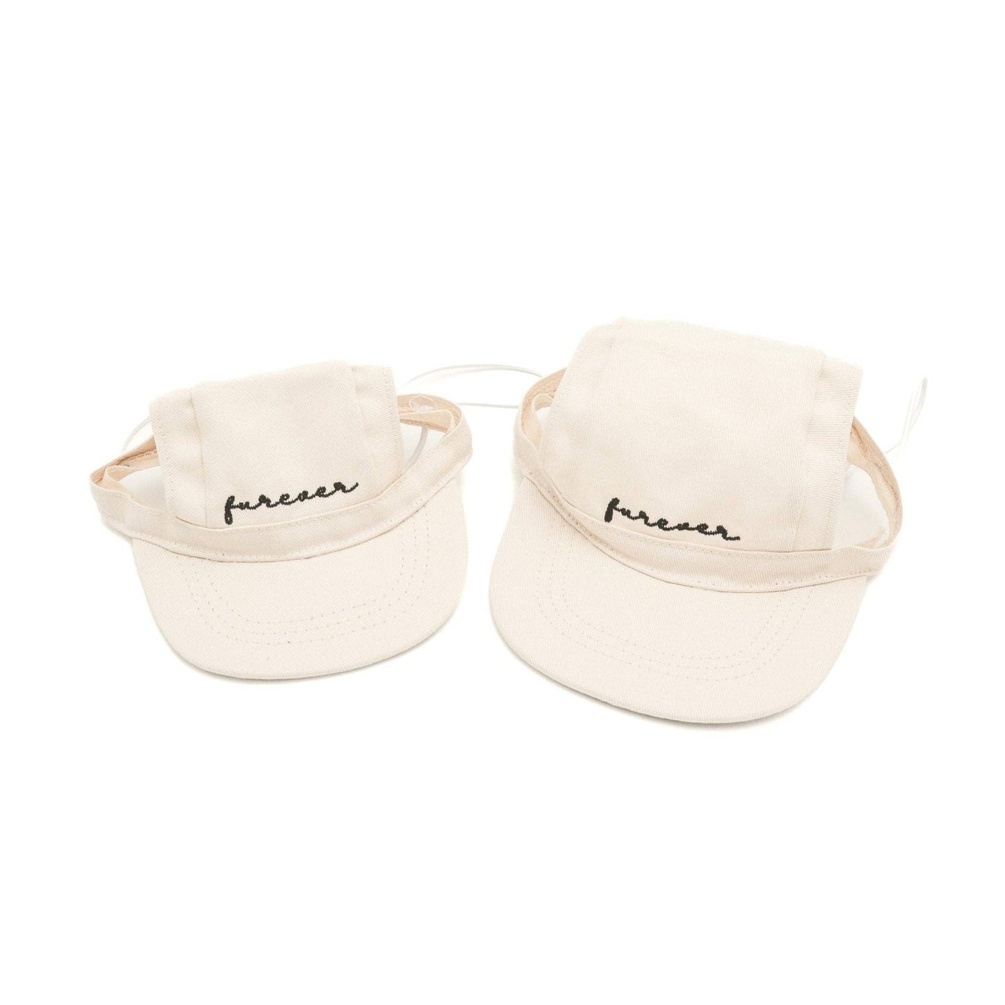 Two cream-colored baseball caps with 'furever' text on a white background