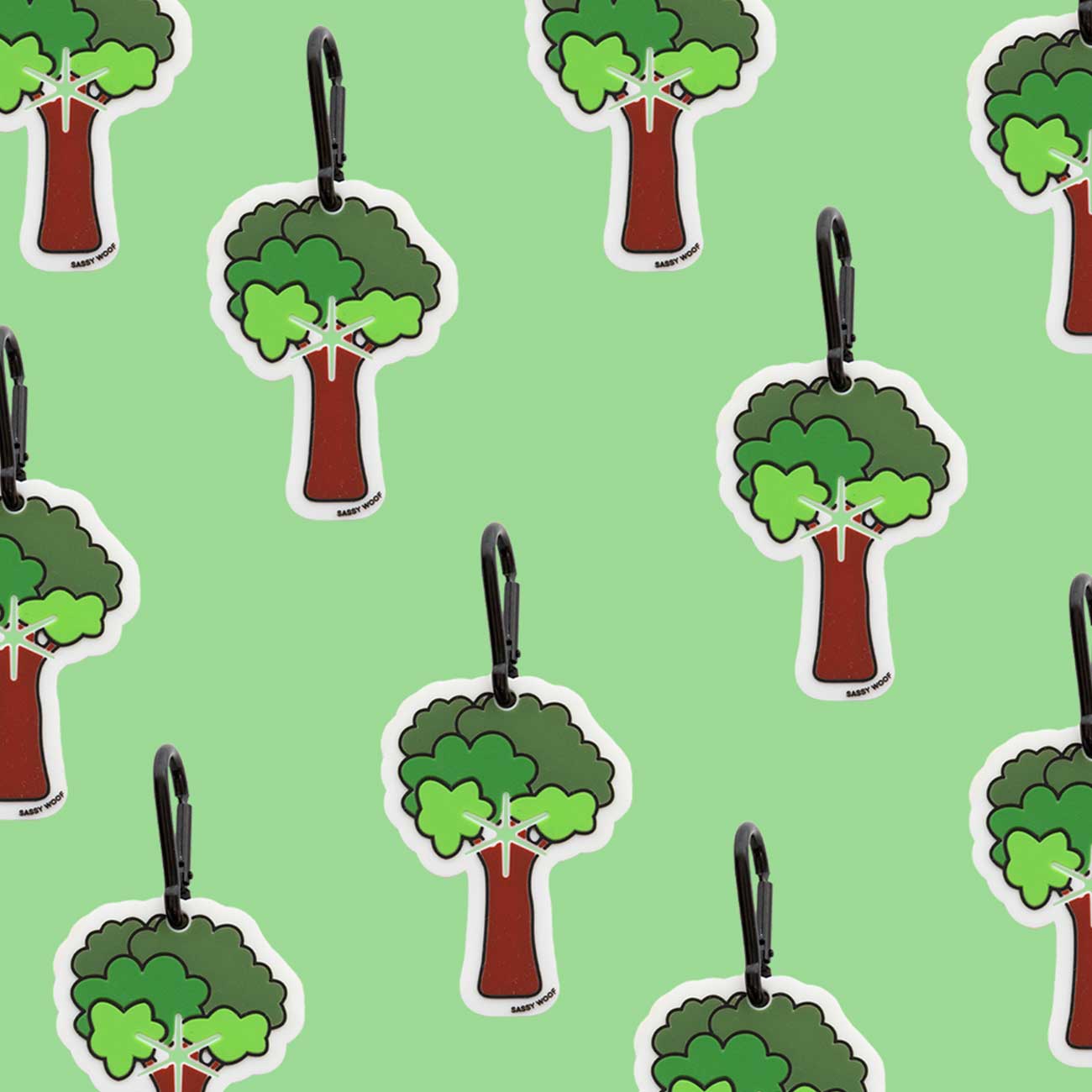 Tree-shaped dog waste bag holder with green leaves and brown trunks on a light green background