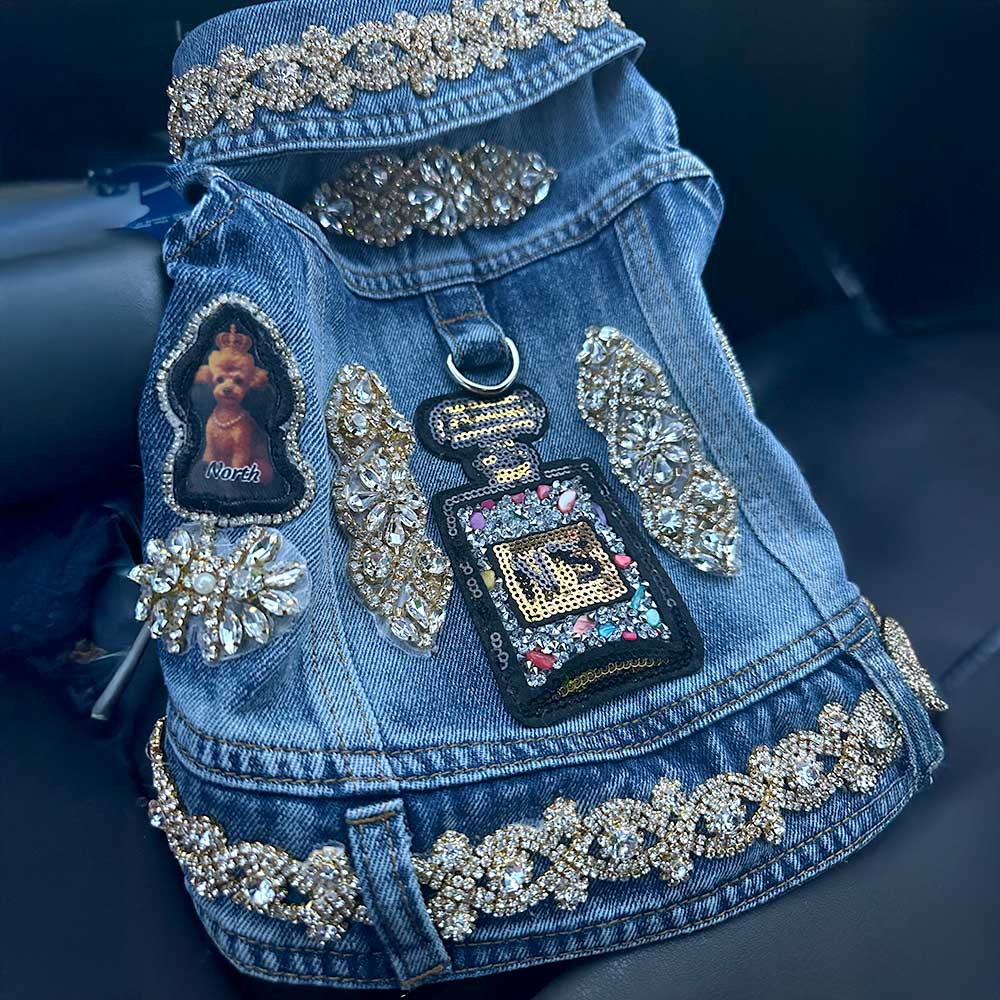 Blue denim jacket with rhinestone embellishments on a dark background