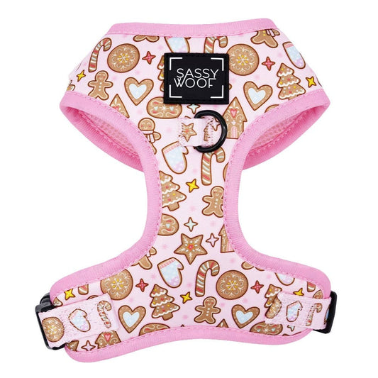 Dog harness with gingerbread pattern and pink border, branded 'Sassy Woof'.