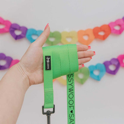 Hand wearing a green wrist wrap with a colorful heart-shaped background