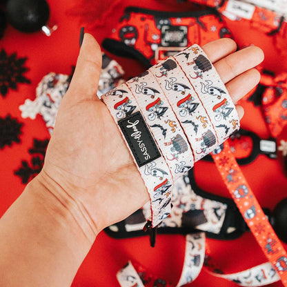 Hand holding a patterned strap with a visible brand label against a red background
