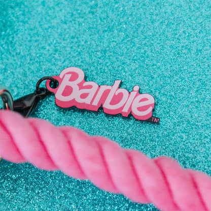 Barbie keychain with pink rope on a turquoise textured background