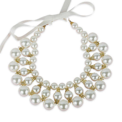 Dog pearl necklace with gold accents and a white ribbon on a white background