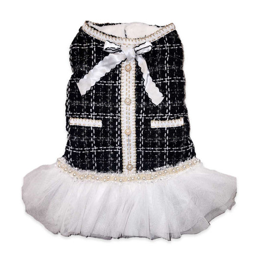 Dog dress with black tweed pattern, white bow, and skirt on a white background