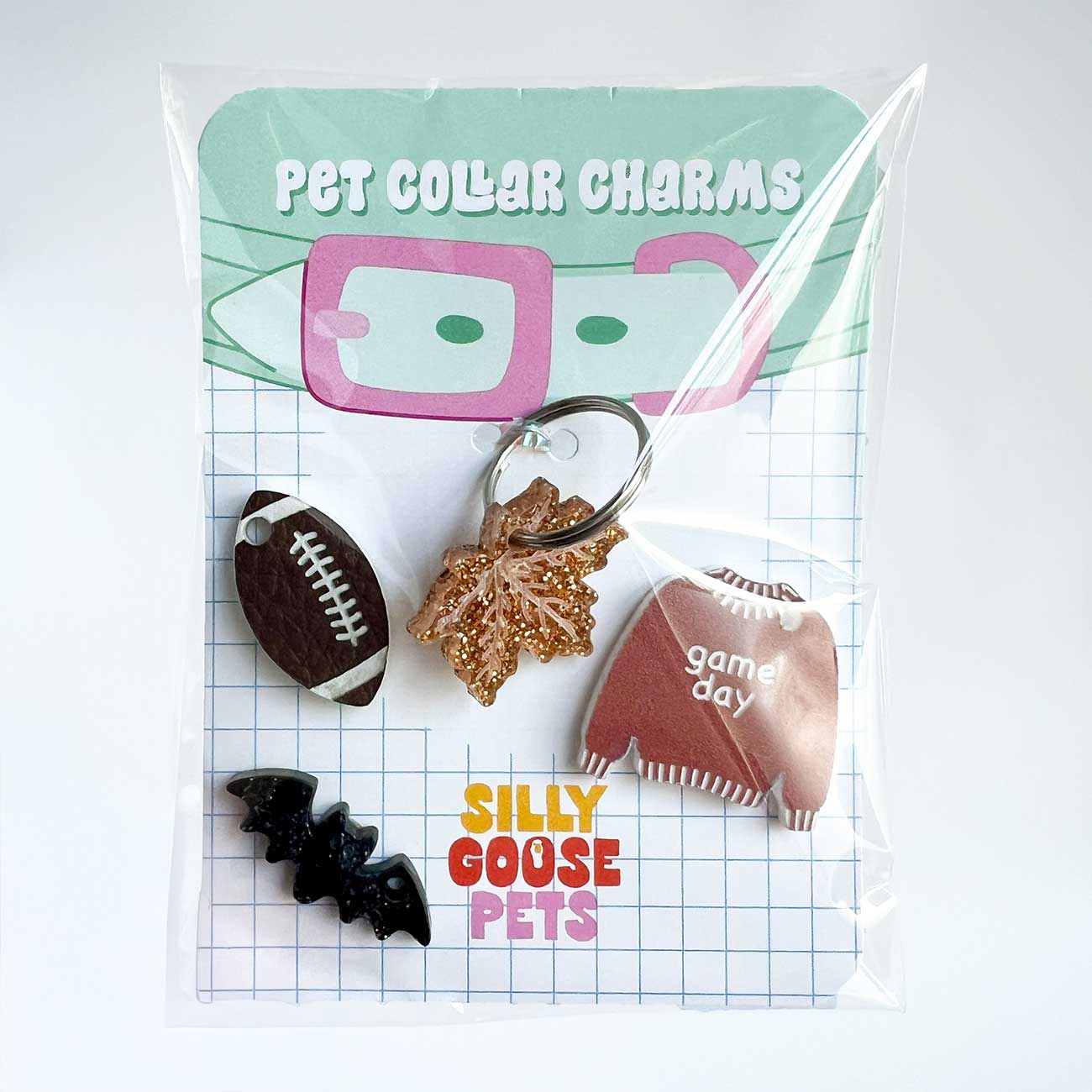Pet collar charms in clear packaging with 'Silly Goose Pets' branding on a white background.
