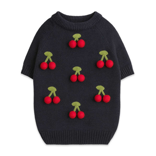 Black dog sweater with red cherry designs on a white background