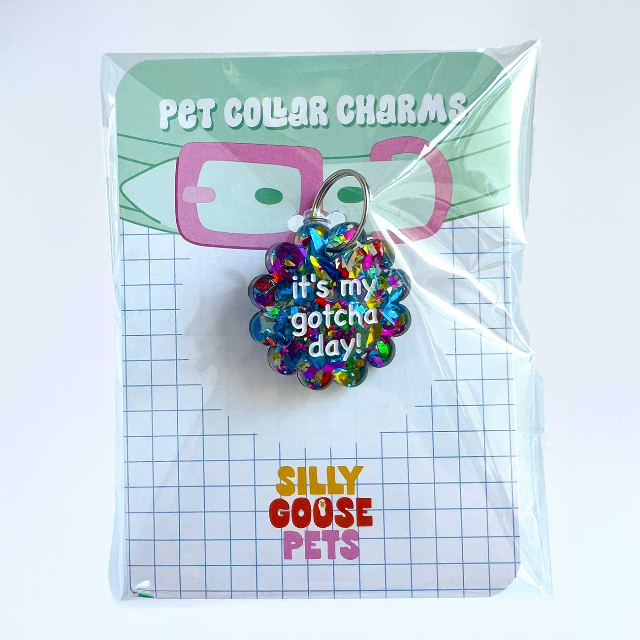 Colorful pet collar charm with text on a 'Silly Goose Pets' branded card.