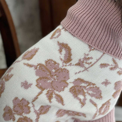 Floral-patterned fabric with a pink knit sleeve in the background
