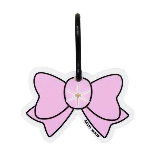Pink bow-shaped dog waste bag holder with a black handle on a white background