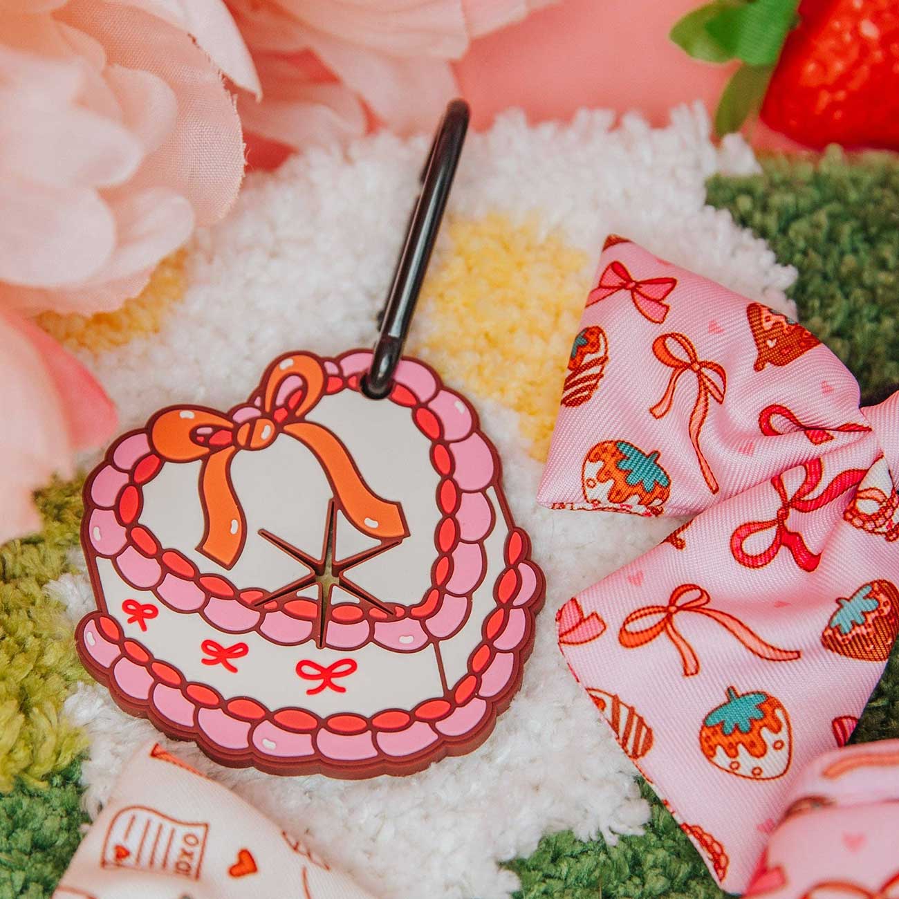 Heart-shaped dog waste bag holder with decorative ribbons on a textured surface with flowers and strawberries.