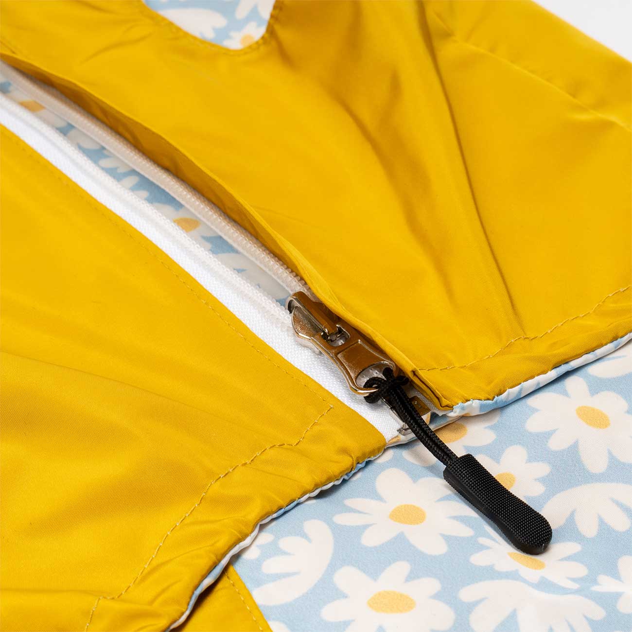 Close-up of a yellow dog jacket with a floral lining and zipper