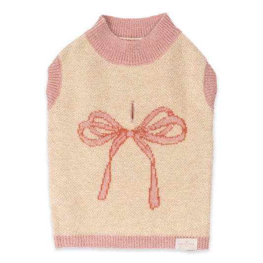 Dog sweater with pink bow design on a beige background