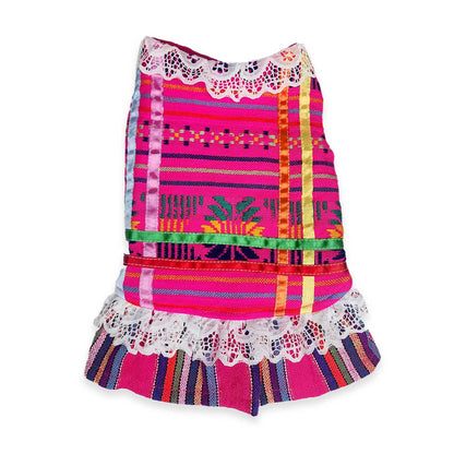Colorful dog dress with patterns and lace details on a white background