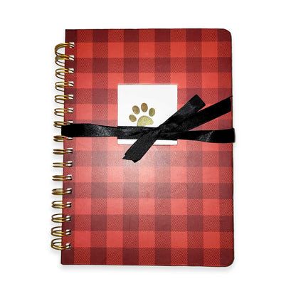 Red plaid notebook with a black ribbon and paw print on a white background