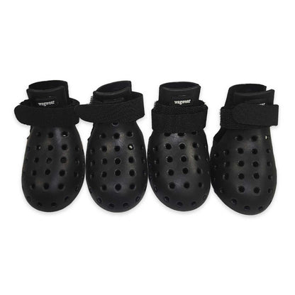 Four black dog boots with ventilation holes on a white background
