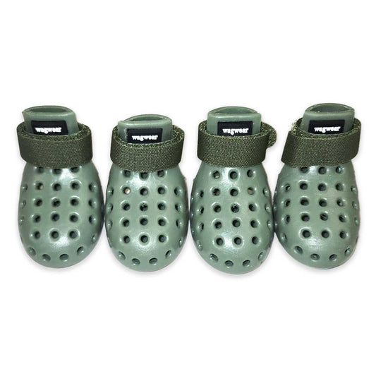 Four green dog booties with ventilation holes on a white background